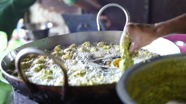 This is closeup shot of Hand-frying fritters in Indian street food during monsoons.