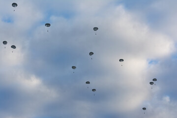 silhouettes of military paratroopers with colorful clouds at sunrise