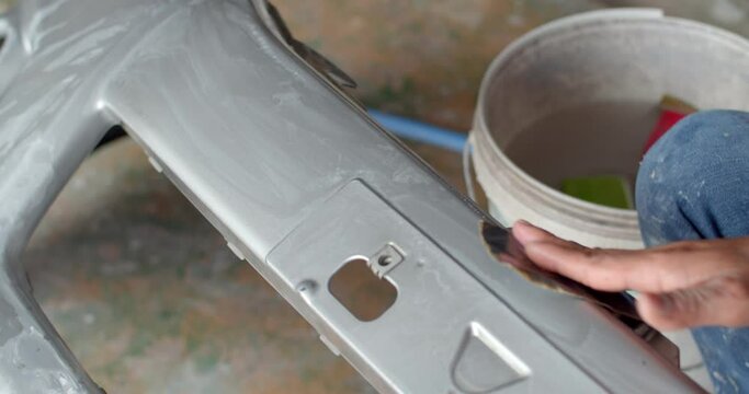 Polishing sandpaper with water to prepare the surface for further painting.
