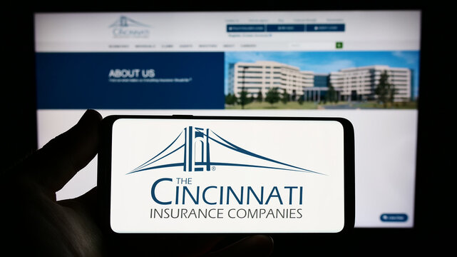 Stuttgart, Germany : 06-25-2023: Person holding smartphone with logo of US company Cincinnati Financial Corporation on screen in front of website. Focus on phone display.