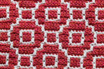 Abstact red white crochet texture. Overlay mosaic crochet pattern close up. Knitted background.