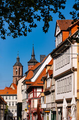 Old town of Göttingen in Lower Saxony Germany with towers of St. Johannis Church, a historic landmark and sight. Pedestrian street with shops seen from “Wilhelmsplatz“ in the city with university.
