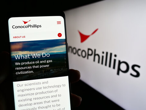 Stuttgart, Germany - 06-25-2023: Person holding smartphone with webpage of US oil and gas business ConocoPhillips Company on screen with logo. Focus on center of phone display.