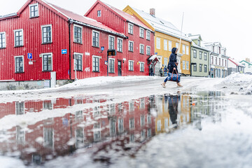 Tourist walking near the multicolored houses of Tromso in winter, Tromso, Norway, Scandinavia