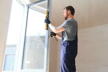 The worker installing and checking window in the house. Concept of new modular houses.