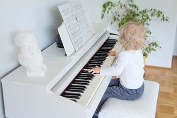 little child playing piano, back view