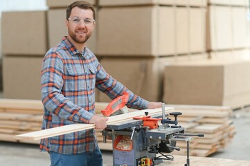Wood cutting table with electric circular saw. Professional carpenter in uniform cutting wooden board at sawmill carpentry manufacturing . Sawing machine