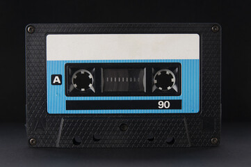 Old vintage audio cassette close up on a black background