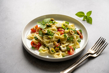 Pasta salad. Traditional Italian pasta with cherry tomatoes, olives, feta cheese, green cabbage.