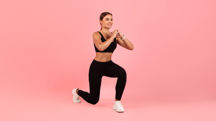 Sporty young female in activewear making lunges exercise in studio