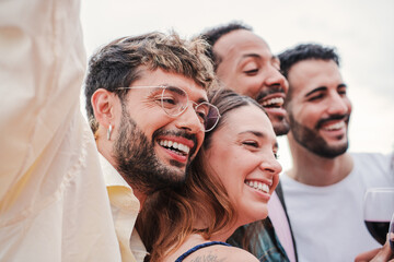 Meeting of smiling group of people celebrating a party, having fun and enjoying the moment together. Young cheerful and excited friends, men and women enjoying a festival. Joyful buddies gathering