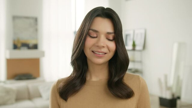 Face emotions series. Closeup cheerful girl staring at camera and flirting with her eyes. Sensual beautiful woman biting lips expressing erotic arousal. Portrait of charming female in modern apartment