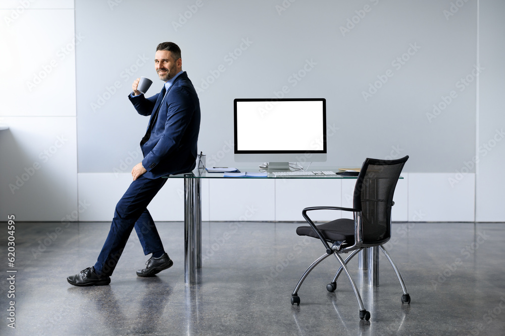 Poster business mock up template. cheerful middle aged man sitting on desk with blank computer screen, free