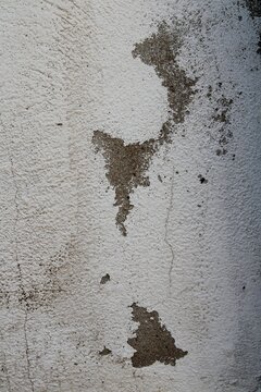 Pared de ladrillos en la casa de campo, con revoque blanco envejecido y agrietado, forma un mapa de material descascarado y da&ntilde;ado por el tiempo, formando un original dise&ntilde;o abstracto para fondos