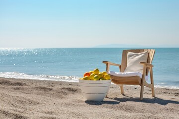 Sun lounger and fruit basket with lemons on the beach with the sea in the background