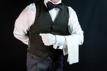 Portrait of Butler or Waiter in Vest and White Gloves With Napkin Draped Over Arm. Concept of Professional Hospitality.