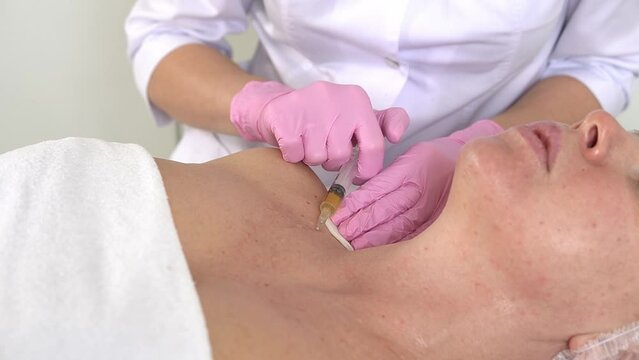 Cosmetologist makes prp-therapy against aging of the skin of the neck and decollete of an adult woman Real procedure. The concept of cosmetology. 