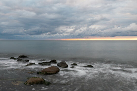 Langzeitbelichtung Sonnenaufgang mit dramatischen Wolken auf der Insel Rügen, Ostsee