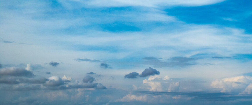 Blue sky with low puffy clouds shot at 50 mm focal length