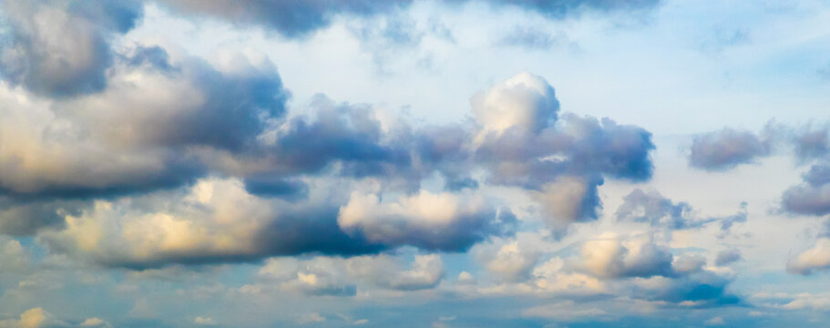 Blue sky with big puffy colorful clouds at sunrise or sunset shot at 54 mm focal length