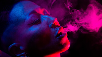 Asian woman with short haircut smoking in neon light. close-up portrait. 