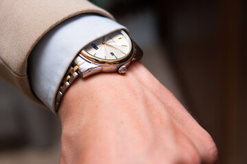 An elegant classic watch under a shirt cuff. Classic men's fashion and a stylish prestige watch