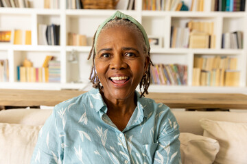 Happy senior african american woman making video call talking to camera in living room