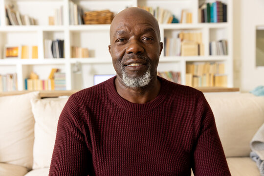 Happy senior african american man making video call smiling to camera in living room - Powered by Adobe