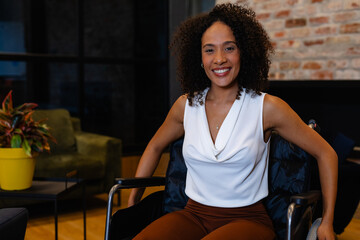 Portrait of happy african american casual businesswoman in wheelchair in office