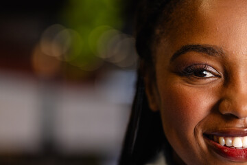 Half portrait of happy african american casual businesswoman in office with copy space