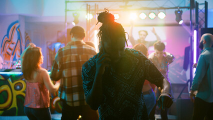 Male adult answering phone call at party, trying to have remote chat at nightclub event. Young man trying to talk on smartphone, partying with electronic music on dance floor. Handheld shot.