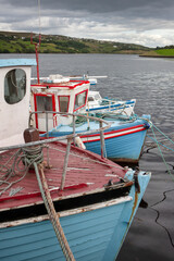 Fototapeta na wymiar Old wooden fishingboats in the harbour of a bay in Ireland. 