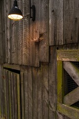 Rustic Charm Illuminated: Outdoor Wall Lamp Casting Light on an Old Wooden Barn, Captured in 4K Resolution