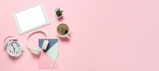 Tablet computer, headphones, alarm clock, notebook and cup of coffee on pink background with space for text