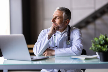 Obraz premium Doctor in hospital office working on laptop at desk