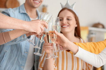 Group of young friends with glasses of champagne celebrating Birthday in kitchen, closeup