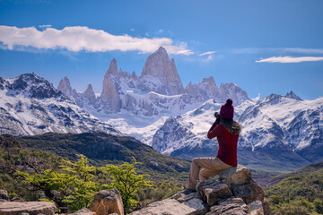Woman sitting on the point view photographing Mount Fitz Roy