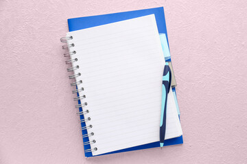 Blank notebook and pen on light background