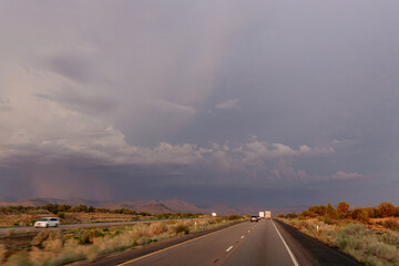 A beautiful asphalt road among hills with dry grass. A scenic landscape with highway, mountains on background and blue sky with fluffy clouds on sunny day. Phoenix, AZ, USA - 7-22-2021