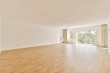 an empty living room with wood flooring and large sliding doors leading out to the balcony area in this home