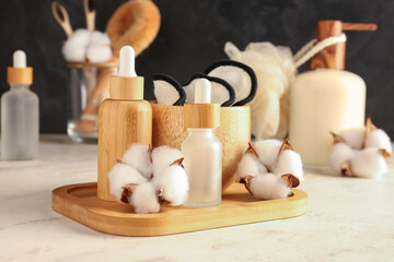 Composition with cosmetic products, bath supplies and cotton flowers on light table