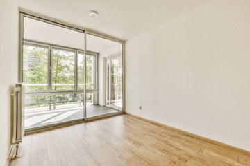 an empty room with wood floors and large windows in the middle part of the apartment there is a sliding glass door