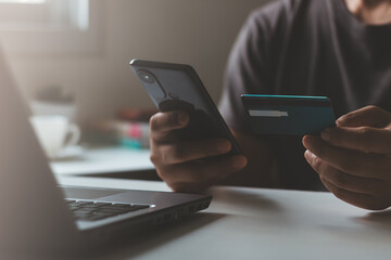 Young asian man makes a purchase on the Internet on the smart phone with credit card, online payment, shopping online, e-commerce, internet banking, spending money, lifestyles technology.