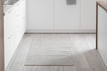 Stylish striped rug in interior of modern kitchen
