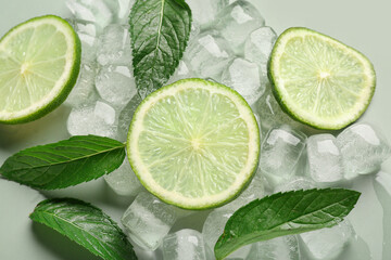 Fototapeta na wymiar Lime slices with ice cubes and mint on green background