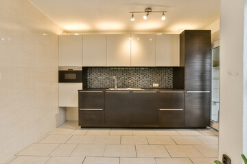 a kitchen area with tile flooring and cabinets on the wall, in an open space that has been used for storage