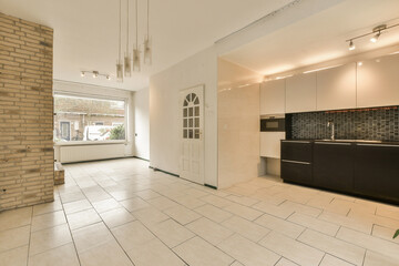 a kitchen area with white tile flooring and black appliances on the stoves in the room is very clean
