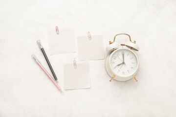 Alarm clock with different stationery on white background