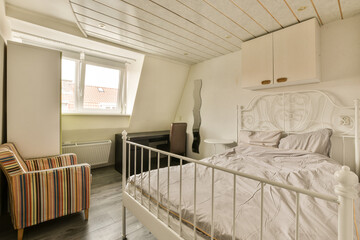 a bedroom with a bed, chair and window in the room that looks out to the cityscapet