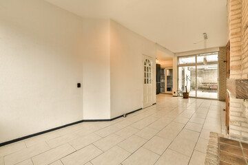 an empty living room with white walls and floor tiles on the floor, there is a fireplace in the corner